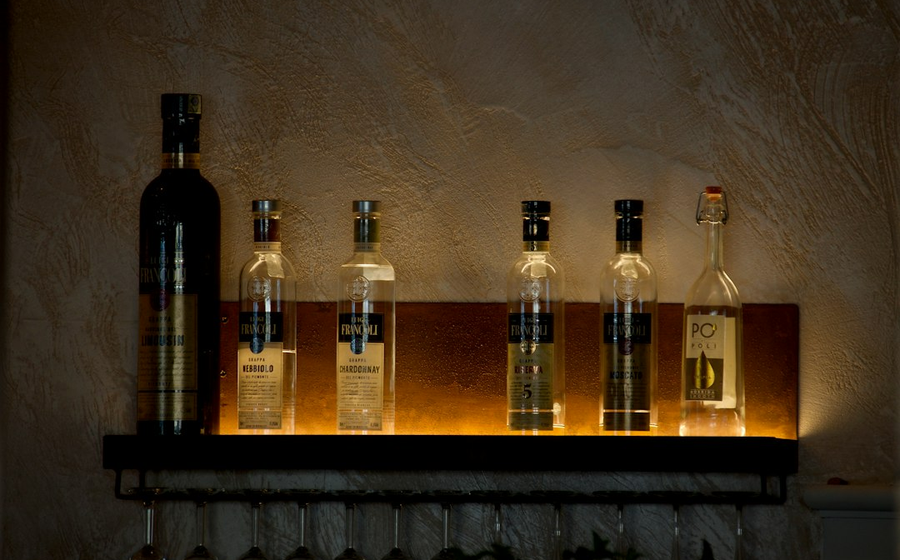 Premium spirit bottles and sparkling wine lit from behind on the service bar